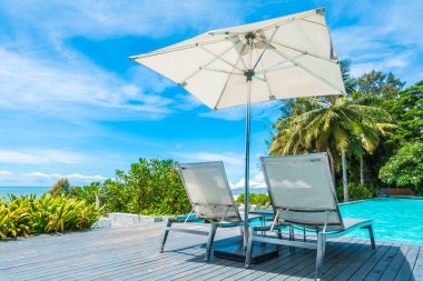 Güzel lüks şemsiye ve sandalye otel ve seyahat ve tatil için tatil yüzme havuzunda çevresinde