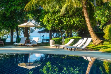 Güzel lüks otel ve tatil seyahat ve tatil için sandalye ve şemsiye ile açık yüzme havuzu