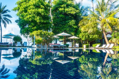Güzel lüks otel ve tatil seyahat ve tatil için sandalye ve şemsiye ile açık yüzme havuzu