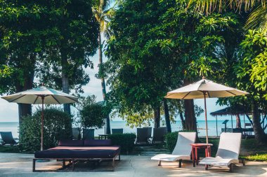 Güzel lüks otel ve tatil seyahat ve tatil için sandalye ve şemsiye ile açık yüzme havuzu