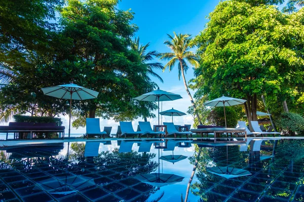Güzel lüks otel ve tatil seyahat ve tatil için sandalye ve şemsiye ile açık yüzme havuzu