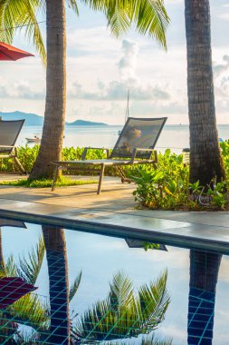 Güzel lüks otel ve tatil seyahat ve tatil için sandalye ve şemsiye ile açık yüzme havuzu