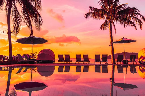Şemsiye ve lüks otel ve gündoğumu zaman seyahat ve tatil için Resort'ta yüzme havuzu etrafında sandalye ile güzel açık görünüm