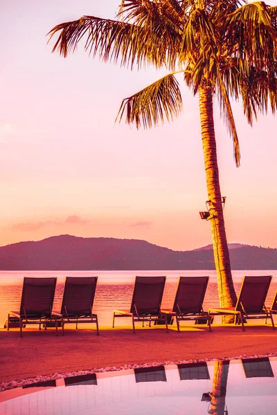 Şemsiye ve lüks otel ve gündoğumu zaman seyahat ve tatil için Resort'ta yüzme havuzu etrafında sandalye ile güzel açık görünüm