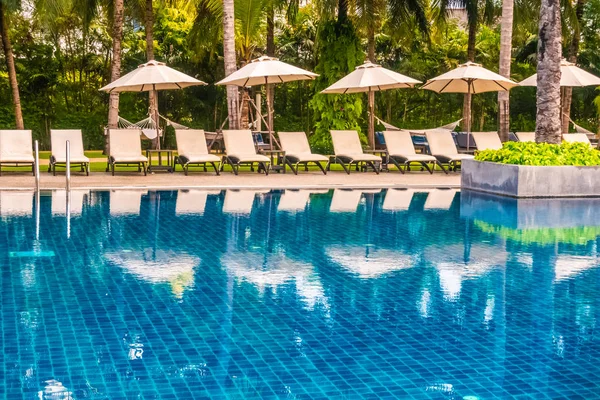 Güzel lüks otel ve tatil seyahat ve tatil için sandalye ve şemsiye ile açık yüzme havuzu