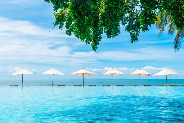 Güzel lüks şemsiye ve sandalye otel ve seyahat ve tatil için tatil yüzme havuzunda çevresinde