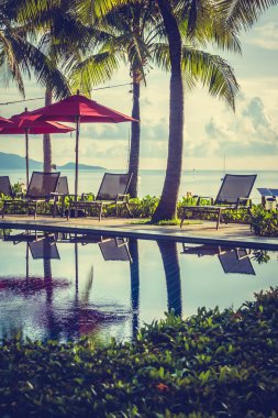 Güzel lüks otel ve tatil seyahat ve tatil için sandalye ve şemsiye ile açık yüzme havuzu