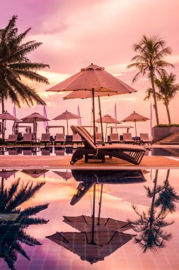 Güzel lüks otel ve tatil seyahat ve tatil için sandalye ve şemsiye ile açık yüzme havuzu