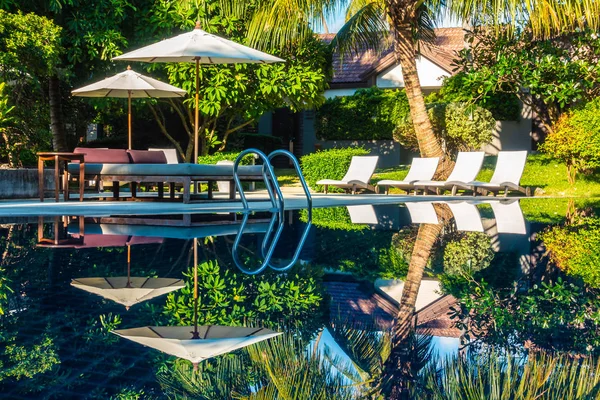 Güzel lüks otel ve tatil seyahat ve tatil için sandalye ve şemsiye ile açık yüzme havuzu
