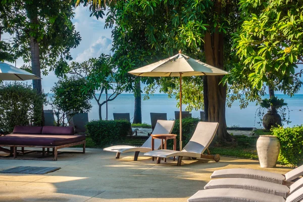 Güzel lüks otel ve tatil seyahat ve tatil için sandalye ve şemsiye ile açık yüzme havuzu