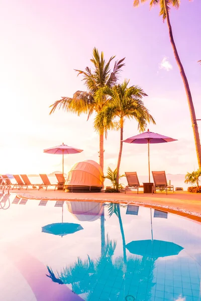 Şemsiye ve lüks otel ve gündoğumu zaman seyahat ve tatil için Resort'ta yüzme havuzu etrafında sandalye ile güzel açık görünüm