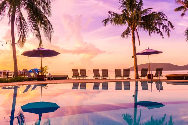 Şemsiye ve lüks otel ve gündoğumu zaman seyahat ve tatil için Resort'ta yüzme havuzu etrafında sandalye ile güzel açık görünüm