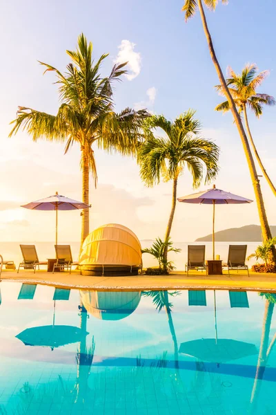 Şemsiye ve lüks otel ve gündoğumu zaman seyahat ve tatil için Resort'ta yüzme havuzu etrafında sandalye ile güzel açık görünüm