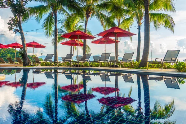 Güzel lüks otel ve tatil seyahat ve tatil için sandalye ve şemsiye ile açık yüzme havuzu