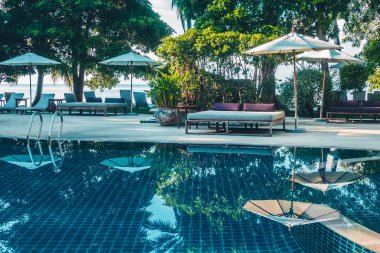 Güzel lüks otel ve tatil seyahat ve tatil için sandalye ve şemsiye ile açık yüzme havuzu