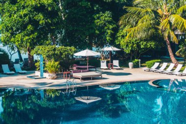 Güzel lüks otel ve tatil seyahat ve tatil için sandalye ve şemsiye ile açık yüzme havuzu