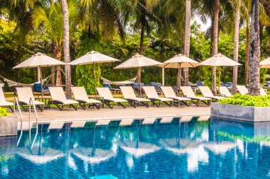 Güzel lüks otel ve tatil seyahat ve tatil için sandalye ve şemsiye ile açık yüzme havuzu