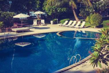 Güzel lüks otel ve tatil seyahat ve tatil için sandalye ve şemsiye ile açık yüzme havuzu