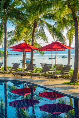 Güzel lüks otel ve tatil seyahat ve tatil için sandalye ve şemsiye ile açık yüzme havuzu