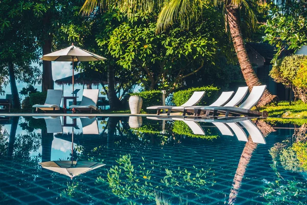 Güzel lüks otel ve tatil seyahat ve tatil için sandalye ve şemsiye ile açık yüzme havuzu
