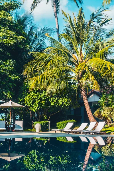 Güzel lüks otel ve tatil seyahat ve tatil için sandalye ve şemsiye ile açık yüzme havuzu