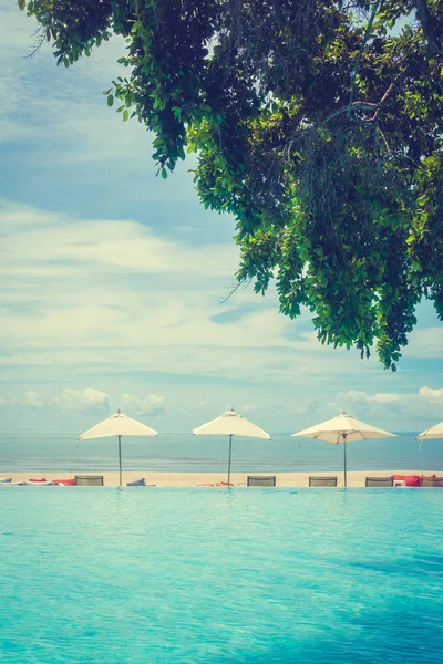 Güzel lüks şemsiye ve sandalye otel ve seyahat ve tatil için tatil yüzme havuzunda çevresinde