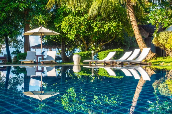 Güzel lüks otel ve tatil seyahat ve tatil için sandalye ve şemsiye ile açık yüzme havuzu