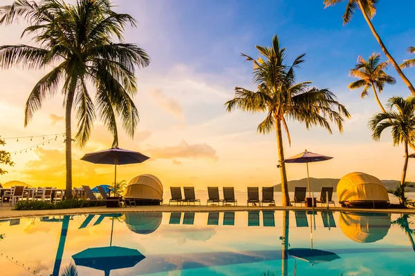 Şemsiye ve lüks otel ve gündoğumu zaman seyahat ve tatil için Resort'ta yüzme havuzu etrafında sandalye ile güzel açık görünüm