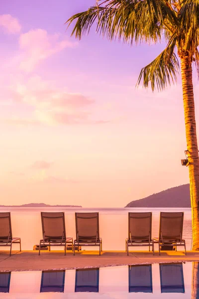 Şemsiye ve lüks otel ve gündoğumu zaman seyahat ve tatil için Resort'ta yüzme havuzu etrafında sandalye ile güzel açık görünüm