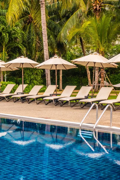 Güzel lüks otel ve tatil seyahat ve tatil için sandalye ve şemsiye ile açık yüzme havuzu