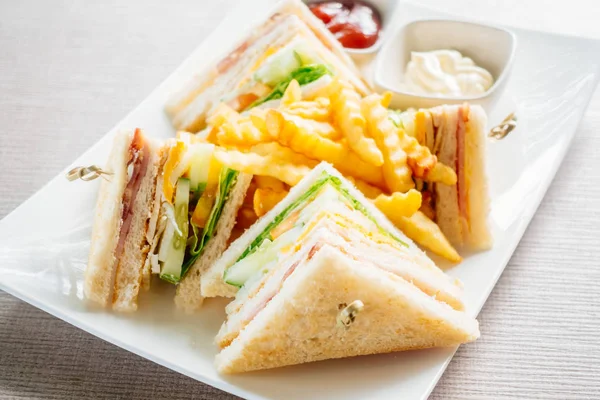 Club sandviç pastırma peynir, jambon sebze ve sos beyaz plaka ile