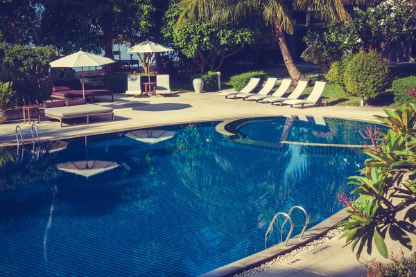 Güzel lüks otel ve tatil seyahat ve tatil için sandalye ve şemsiye ile açık yüzme havuzu