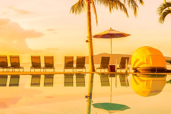 Şemsiye ve lüks otel ve gündoğumu zaman seyahat ve tatil için Resort'ta yüzme havuzu etrafında sandalye ile güzel açık görünüm