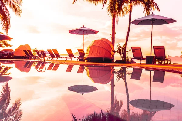 Şemsiye ve lüks otel ve gündoğumu zaman seyahat ve tatil için Resort'ta yüzme havuzu etrafında sandalye ile güzel açık görünüm