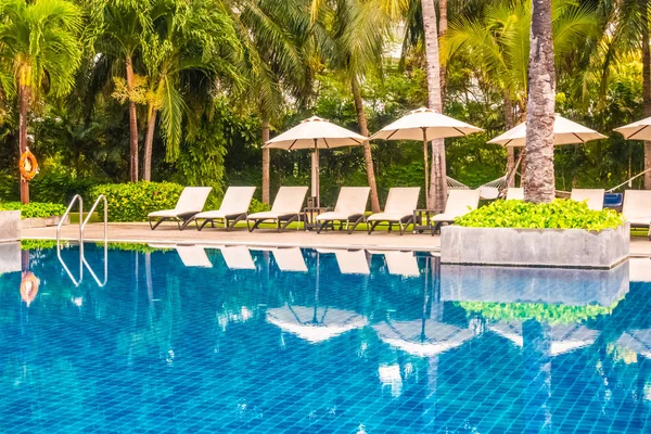 Güzel lüks otel ve tatil seyahat ve tatil için sandalye ve şemsiye ile açık yüzme havuzu