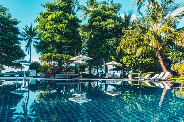 Güzel lüks otel ve tatil seyahat ve tatil için sandalye ve şemsiye ile açık yüzme havuzu