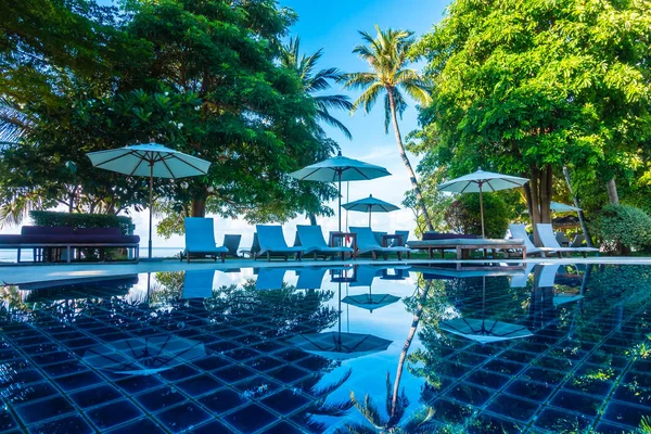 Güzel lüks otel ve tatil seyahat ve tatil için sandalye ve şemsiye ile açık yüzme havuzu
