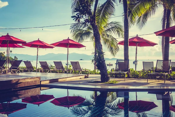 Güzel lüks otel ve tatil seyahat ve tatil için sandalye ve şemsiye ile açık yüzme havuzu