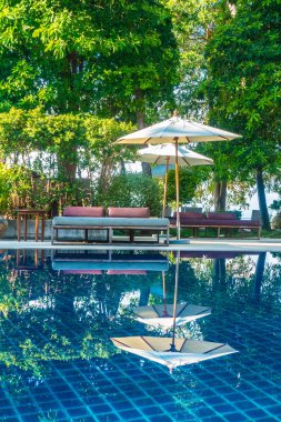Güzel lüks otel ve tatil seyahat ve tatil için sandalye ve şemsiye ile açık yüzme havuzu