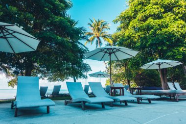 Güzel lüks otel ve tatil seyahat ve tatil için sandalye ve şemsiye ile açık yüzme havuzu