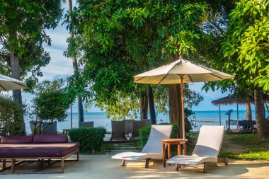 Güzel lüks otel ve tatil seyahat ve tatil için sandalye ve şemsiye ile açık yüzme havuzu