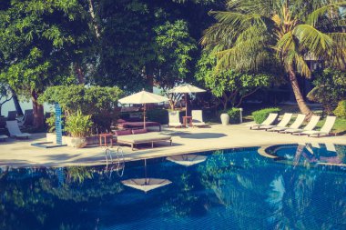 Güzel lüks otel ve tatil seyahat ve tatil için sandalye ve şemsiye ile açık yüzme havuzu