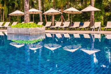 Güzel lüks otel ve tatil seyahat ve tatil için sandalye ve şemsiye ile açık yüzme havuzu