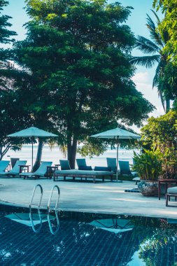 Güzel lüks otel ve tatil seyahat ve tatil için sandalye ve şemsiye ile açık yüzme havuzu