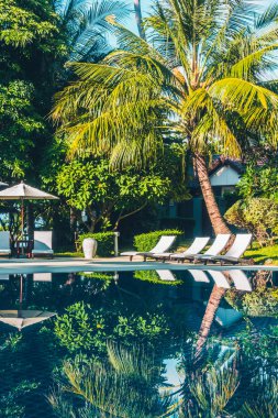 Güzel lüks otel ve tatil seyahat ve tatil için sandalye ve şemsiye ile açık yüzme havuzu