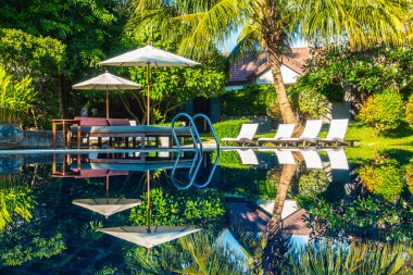 Güzel lüks otel ve tatil seyahat ve tatil için sandalye ve şemsiye ile açık yüzme havuzu