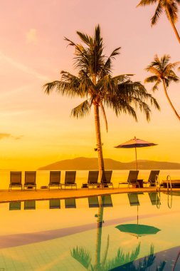 Şemsiye ve lüks otel ve gündoğumu zaman seyahat ve tatil için Resort'ta yüzme havuzu etrafında sandalye ile güzel açık görünüm