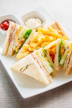 Club sandviç pastırma peynir, jambon sebze ve sos beyaz plaka ile