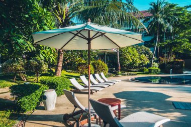 Güzel lüks otel ve tatil seyahat ve tatil için sandalye ve şemsiye ile açık yüzme havuzu