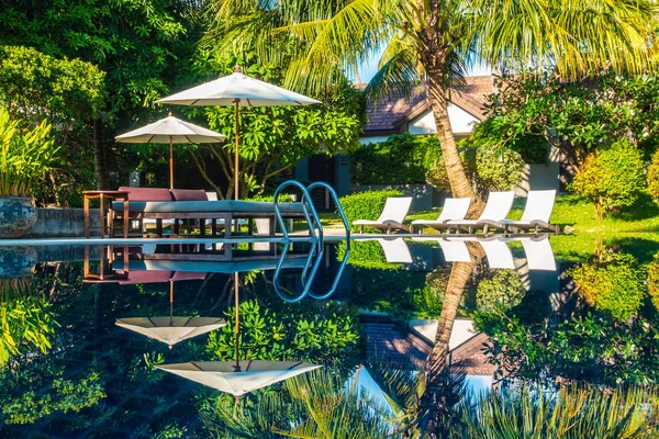 Güzel lüks otel ve tatil seyahat ve tatil için sandalye ve şemsiye ile açık yüzme havuzu